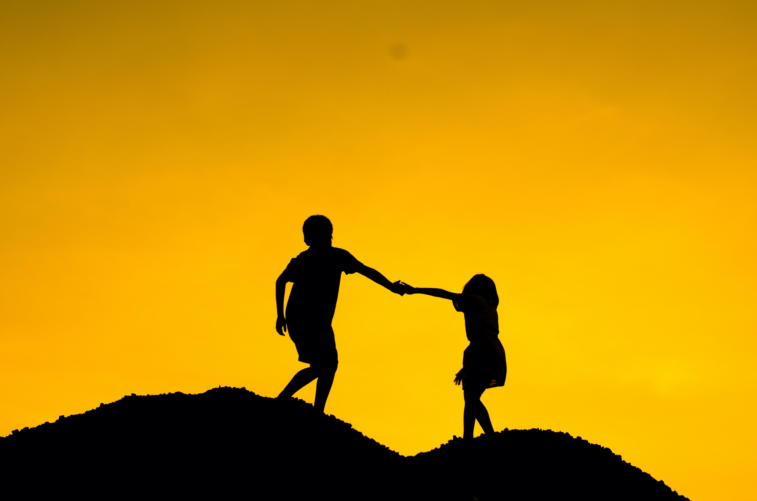 Boy holding girl hand for climbing higher, mentor concept.